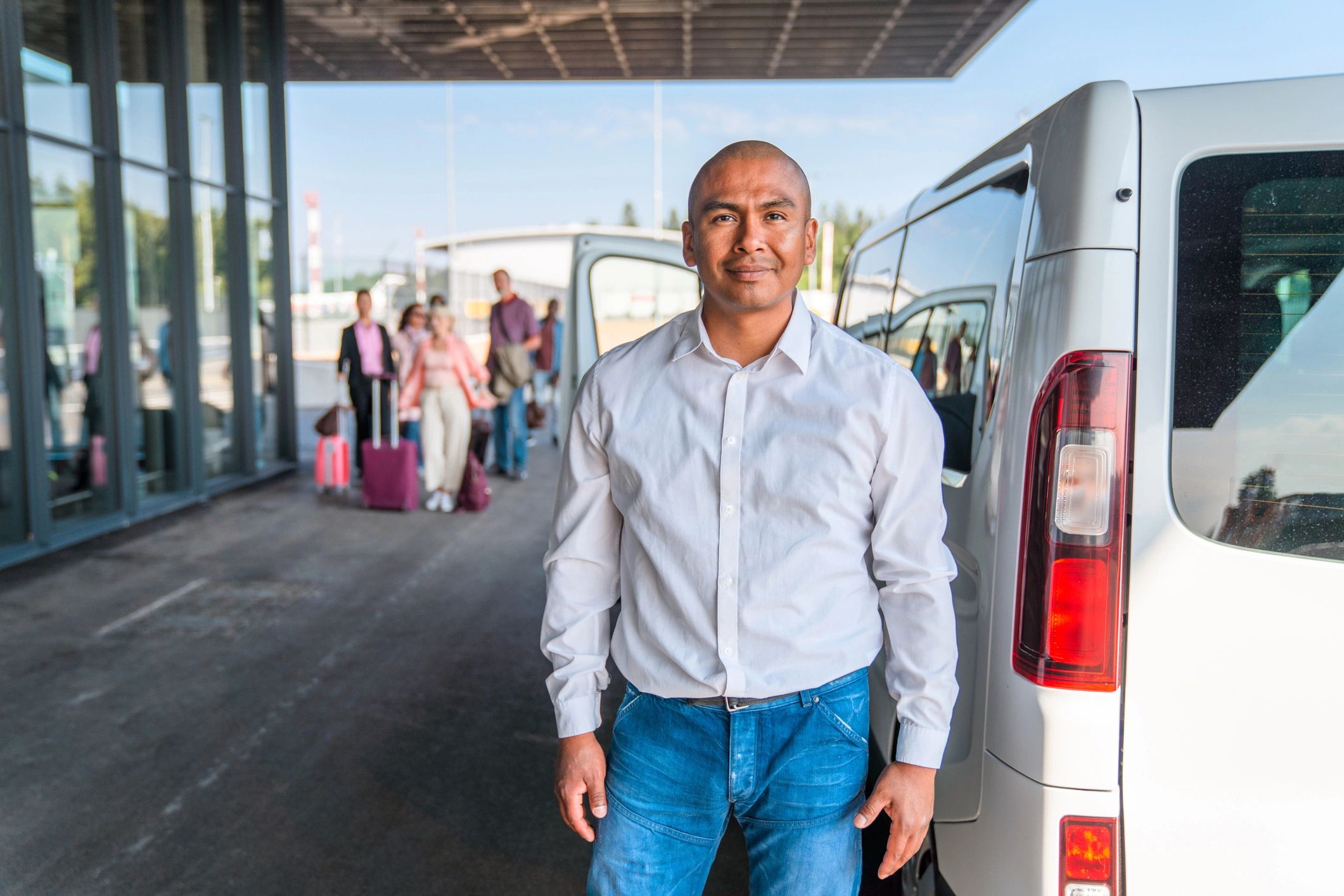 Friendly shuttle driver assisting traveler